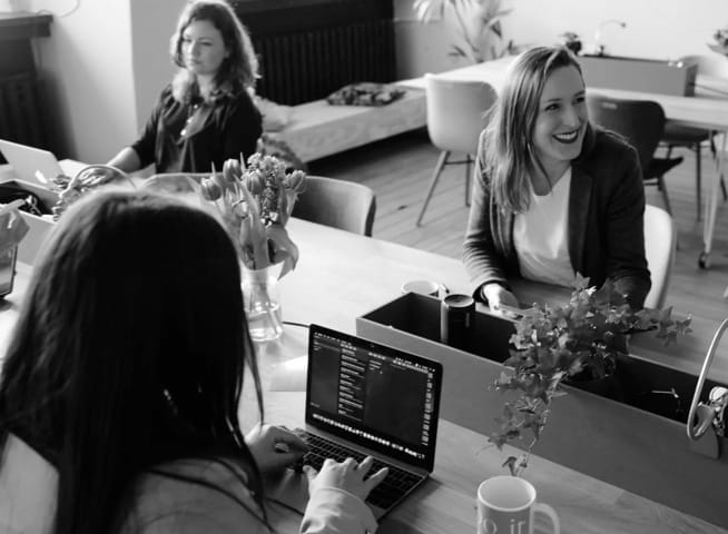 People working at a table with their computers 